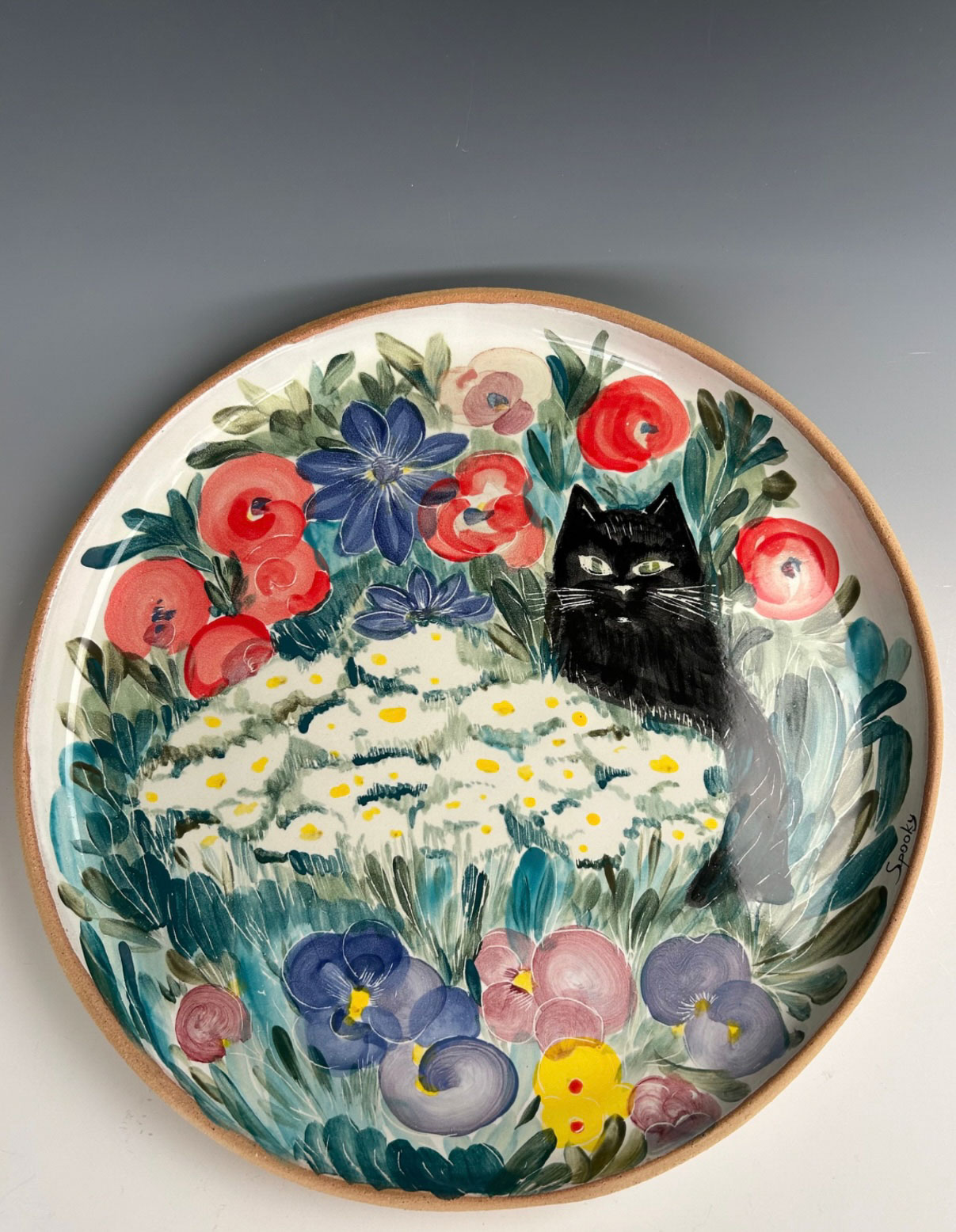 Liya Snyder, Grand Forks, ND, USA. “Cat in the Garden,” stoneware, hand painted on raw enamel.
