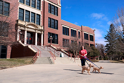 Student Amber Holcomb and her dogs in front of Old Main